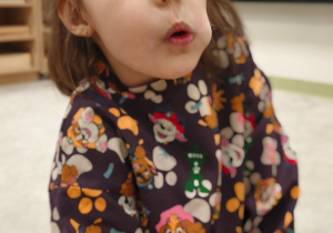 Dziewyczynka wypycha policzek językiem