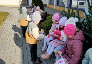 Dziewczynki otrzymuja kolejne znalezione upominki do kolegów.