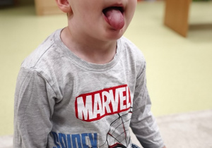 Chłopiec próbuje położyć język na brodzie