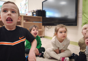 Chłopiec ćwiczy z dziećmi liczenie zębów językiem