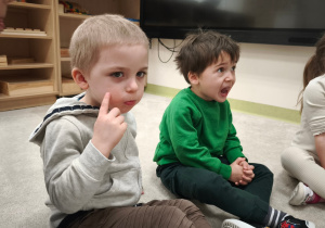 Chłopiec robi balonik z policzków