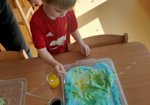 Oliwier tworzy pracę plastyczną