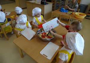 dzieci zrzucają owoce do miski