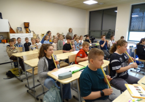 38 Dzieci w sali muzycznej słuchają, jak grają uczniowie na flecie