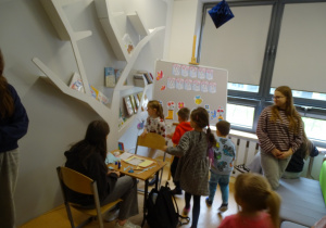 64 Dzieci szukają w bibliotece naklejek książek
