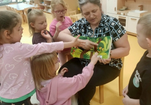 Dzieci wspólnie z Panią oglądają książki