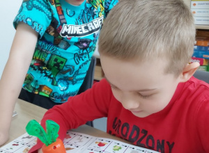 Chłopcy rozwiązują zadanie słuchowe z grą "Magiczna marchewka"