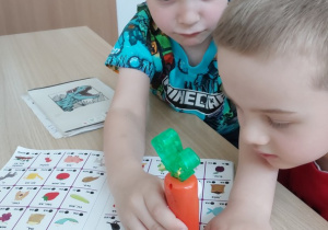 Chłopoec dobiera brakującą sylabę z zabawką -magiczną marchewką