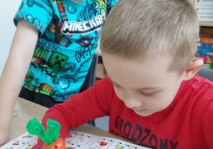 Chłopcy rozwiązują zadanie słuchowe z grą "Magiczna marchewka"