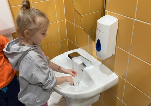 Dziewczynka myje ręce według odpowiednich etapów.