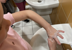 Dziewczynki myje ręce według odpowiednich etapów.