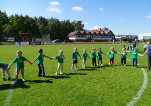 dzieci podczas rozgrzewki na stadionie