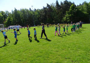 dzieci podczas rozgrzewki na stadionie