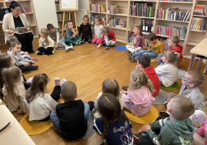 Dzieci słuchają bajki czytanej przez panią.