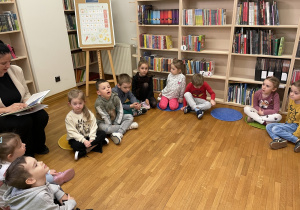 Dzieci słuchają bajki czytanej przez panią.