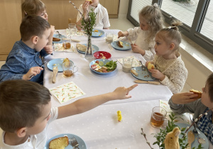 Dzieci jedzą śniadanie wielkanocne.