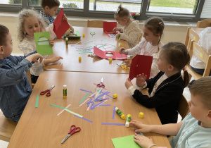 Dzieci wykonują kartki wielkanocne z życzeniami dla rodziców.