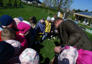 Dzieci sadzą drzewko z leśniczym.