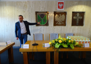 Wójt pokazuje herb gminy