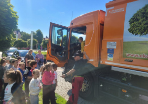Dzieci wsiadają do smieciarki