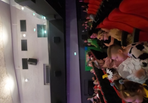 Dzieci w oczekiwaniu na swoją kolej, oglądają występy na scenie.