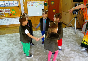 Dzieci przebrane za misie tańczą w kółeczku