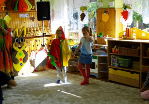 Chłopiec w kolorowej pelerynie przeciwdeszczowej z dziewczynką