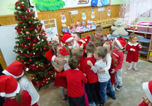 Dzieci przytulają Mikołaja