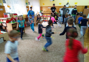 Dzieci biegają po sali wokół rozłożonych na dywanie figiur
