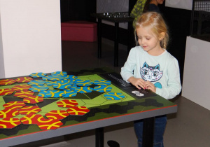 Dziewczynka układa puzzle