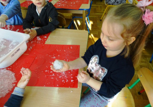 Dzieci lepią ze śniegu kule
