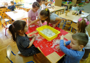Dzieci bawią się sztucznym śniegiem