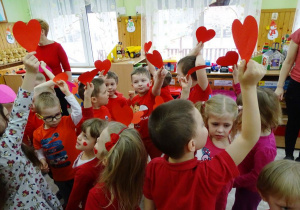 Dzieci z czerwonymi serduszkami stoją razem