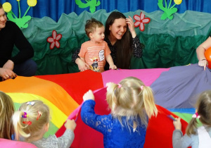 Dzieci bawią się kolorową chustą klanzy
