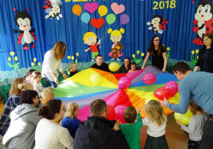 Dzieci podrzucają baloniki na kolorowej chuście klanzy