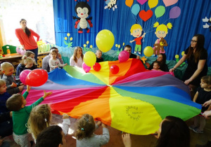 Dzieci podrzucają baloniki na kolorowej chuście klanzy