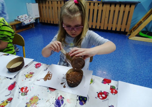 Dziewczynka wylewa czekolade do foremki