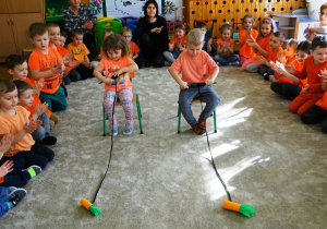Dzieci zwijają sznurek z marchewką
