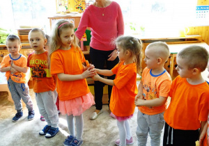 Dzieci podają sobie marchewkę