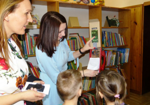 Nauczycielka prezentuje prace konkursową książkę w telefonie