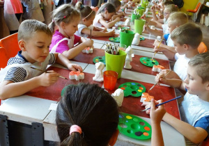 Dzieci malują ceramiczne figurki