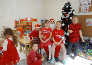 Szymon, Madzia, Iza i Zosia pozują do zdjęcia z Mikołajem.