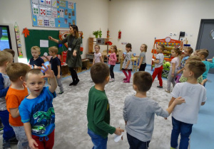 dzieci wraz z nauczycielką tańczą w kole