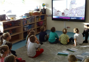 dzieci patrzą na film wyświetlany na tablecie
