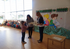 Laureatka konkursu literackiego z grupy 6 - latków odbiera dyplom i nagrodę