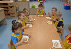 Dzieci jedzą sałatkę.