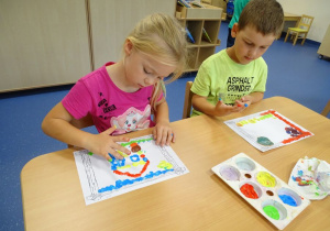 Alinia i Juliuszek malują farbami.