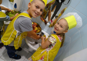 Juliuszek i Lenka dokładnie myją owoce.