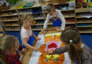 Dzieci malują farbami obrazek misia.