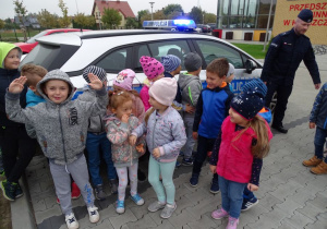 Dzieci przed radiowozem policyjnym